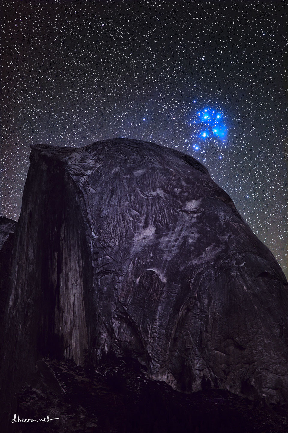 Posnetek prikazuje svetlomodro zvezdno kopico Plejade nad vrhom Half Dome, 
vejo okroglo skalo, ki zgleda temna s svetlimi lisami. 
Ve informacij v pojasnilu.