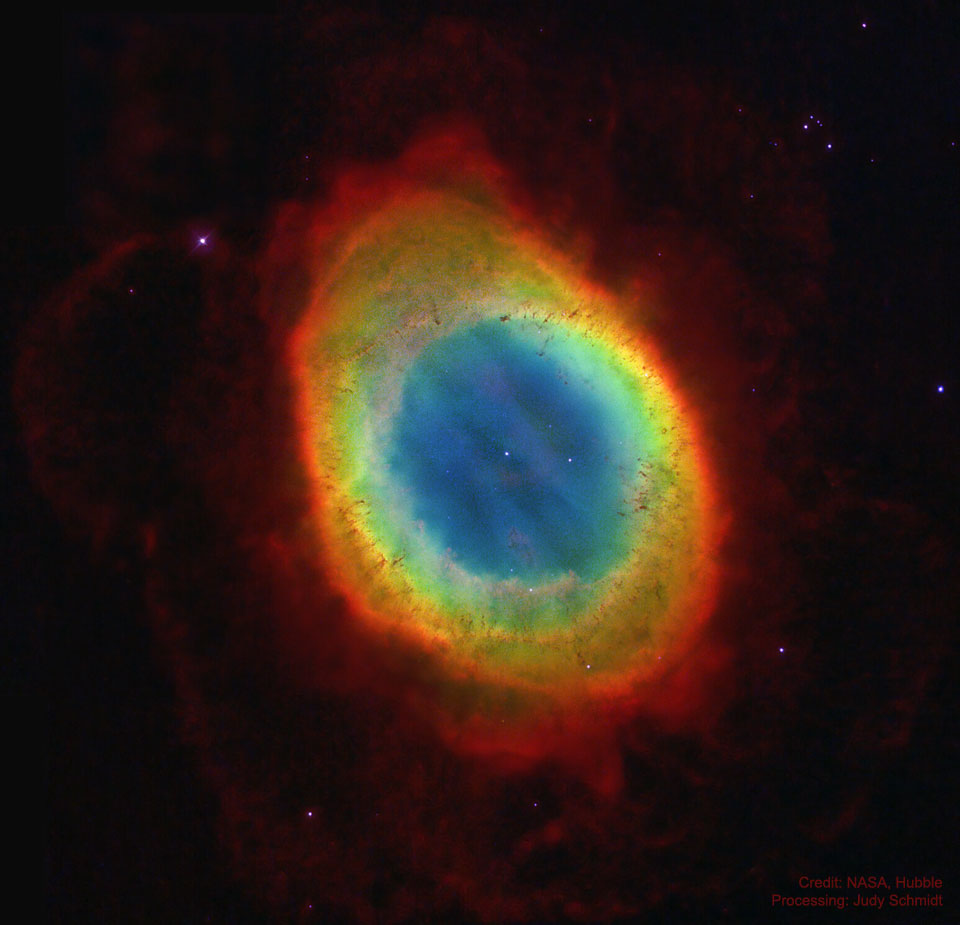 Prikazana je barvita ovalna meglica
v redkem zvezdnem polju. Šibkejša rdeča meglica obdaja
svetel oval. V centru ovala je vidna relativno svetla zvezda.
Za podrobnejše informacije si oglejte razlago.