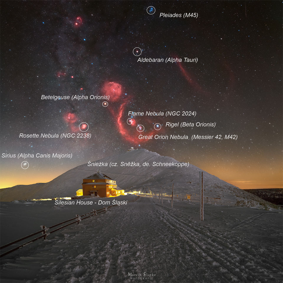A snowy landscape is pictured with a big hill in the center.
Above the hill is a starfield with the stars and nebulae of the
constellation Orion appearing, with the red glow of the
nebulas in great contrast to the dark sky and bright snow.
Please see the explanation for more detailed information.