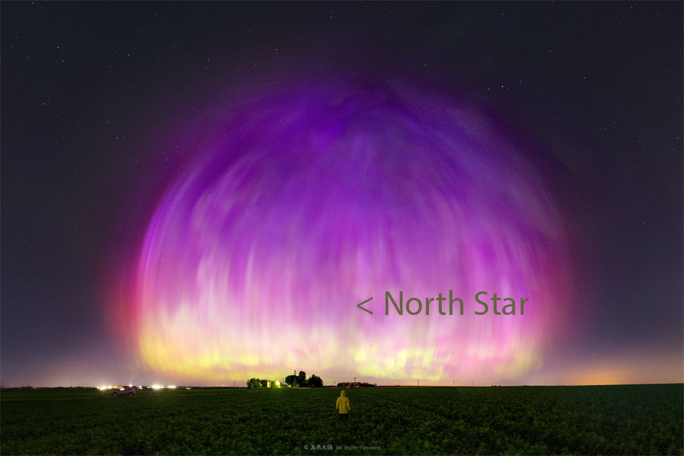 
A large purple transparent dome appears to cover much of a starry
sky. A person stands in a field looking toward the unusual spectacle.
Please see the explanation for more detailed information.