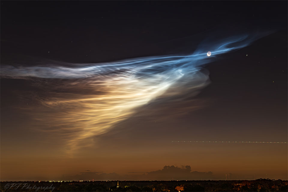 A dawn sky is shown that is black at the top and brown near the
horizon. Wispy clouds converge on the right turning from a white to a
blue hue. Near the apex of this convergence is a crescent moon.
Please see the explanation for more detailed information.