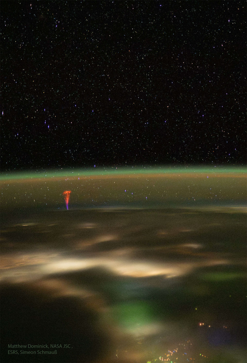 The edge of the Earth is seen from space at night.
The curving horizon is tinted green but a red and blue
jet rises from left.
Please see the explanation for more detailed information.