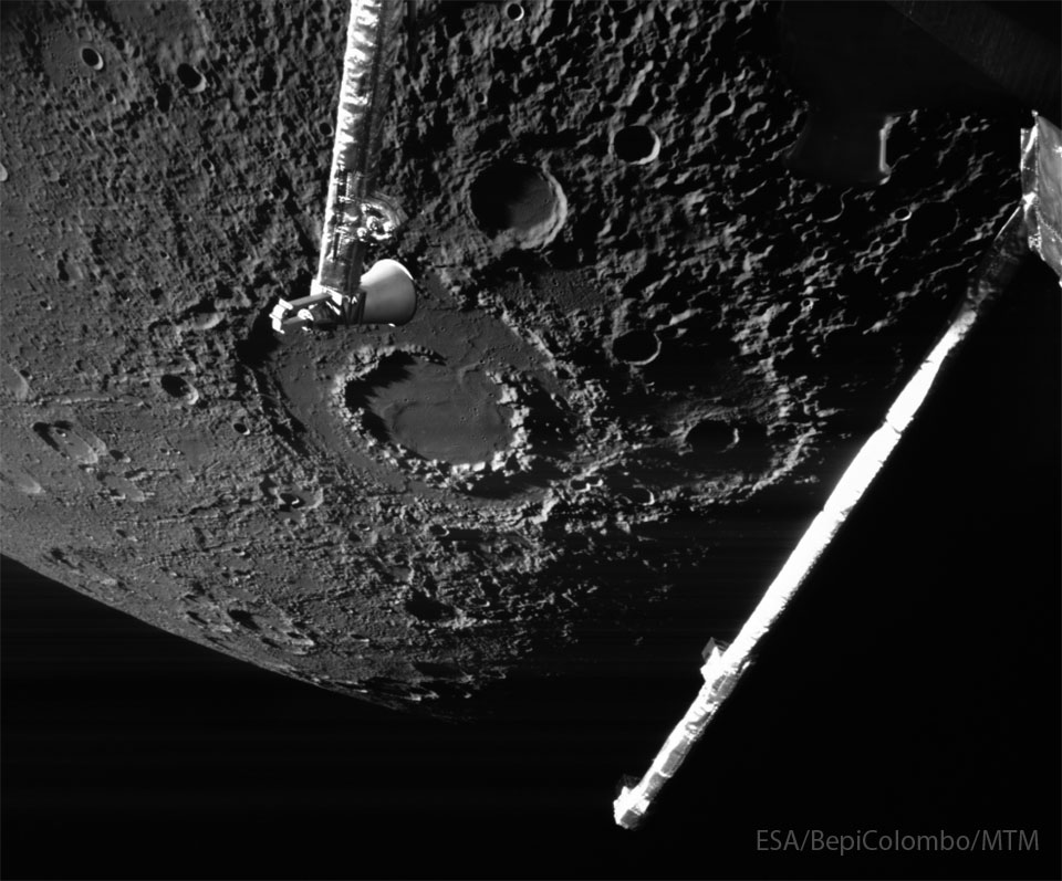 The cratered surface of a large body is shown: Mercury.
The largest feature visible is a large impact crater with two
rings, near the image center. Arms from the BepiColumbo
spacecraft that took the image are seen extending into the
image from the top and the right.
Please see the explanation for more detailed information.