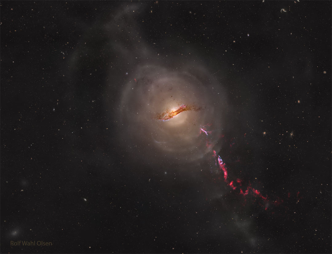 A galaxy is seen in the center of the image. Faint shells are
seen around it. A red-colored jet is seen emanating from the galaxy
toward the lower right.
Please see the explanation for more detailed information.