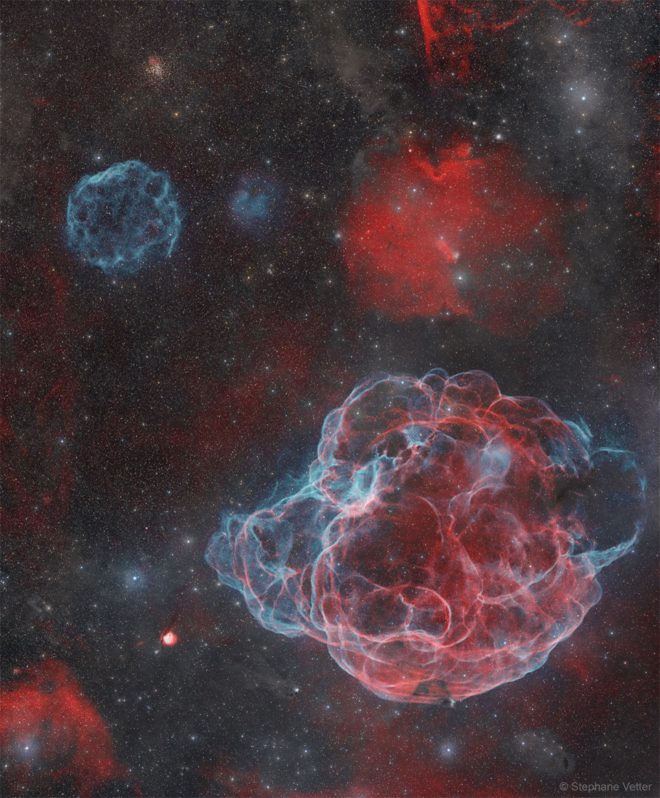 A star field appears that has several nebulas. Toward the upper
left is a angularly small supernova remnant colored blue, while
dominating the lower right is a large supernova remnant in both
red and blue.
Please see the explanation for more detailed information.