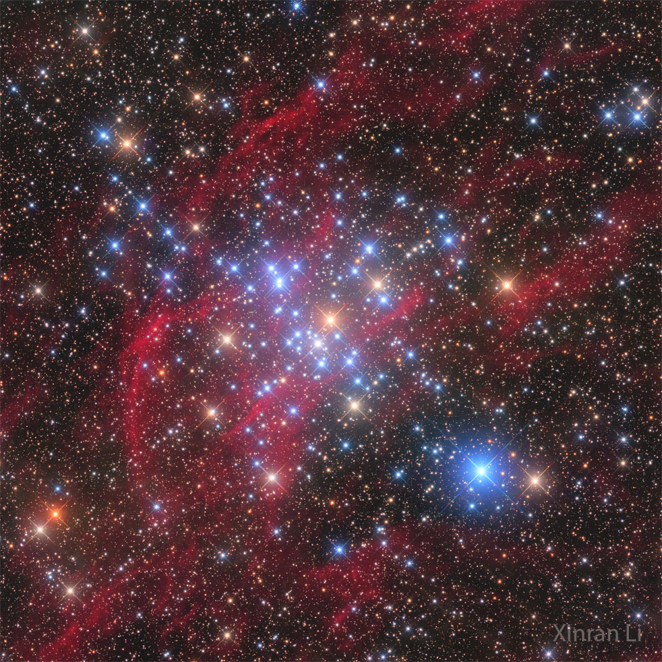 A starscape is shown with red filaments running
diagonally from the lower left to the upper right.
Many bright blue stars are visible across the center
of the frame.
Please see the explanation for more detailed information.