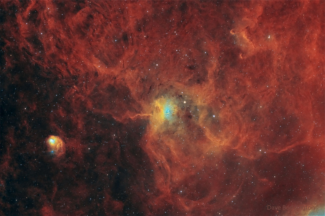 A star field has a red diffuse glow on the right-hand side.
Distinct nebulas appear in the center and on the lower left.
Please see the explanation for more detailed information.