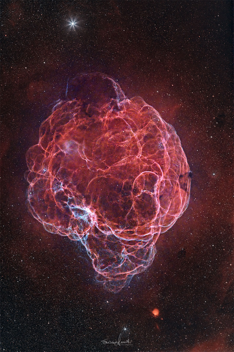 A starfield surrounds a giant red nebula. The nebula has so
many winding filaments that it has been dubbed the Spaghetti Nebula.
Please see the explanation for more detailed information.