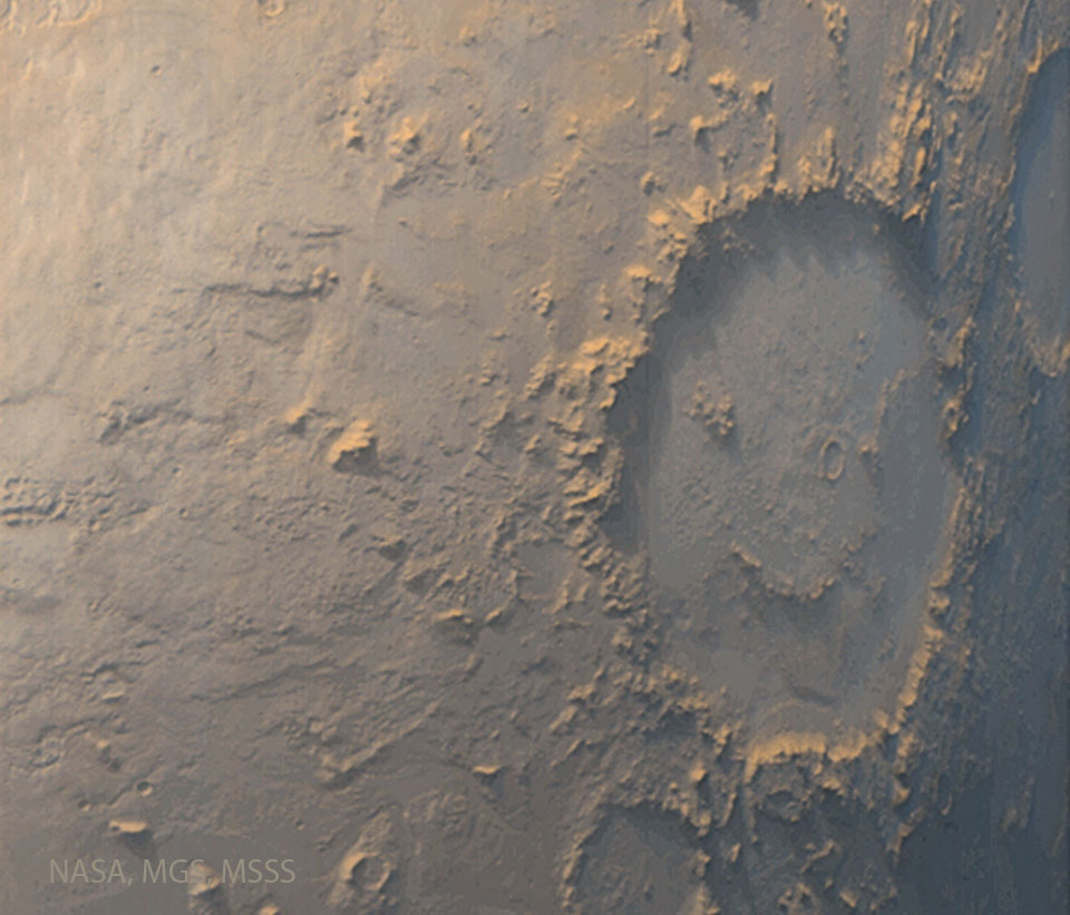Several craters are visible on a tan surface.
The largest crater, on the right, has internal
markings that make it look like a winking face
with a smile.
Please see the explanation for more detailed information.