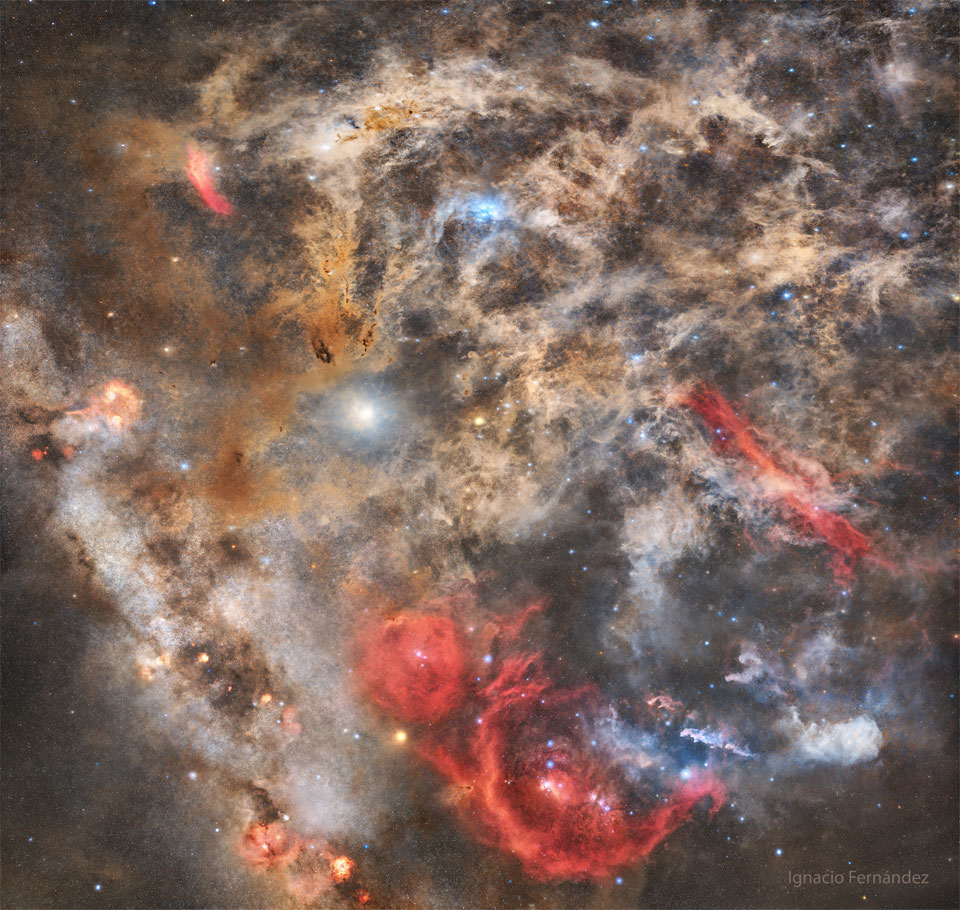 The featured image shows a dusty starfield with intricate
dust filaments all over. Red, blue, and brown nebulas will the
field.
Please see the explanation for more detailed information.