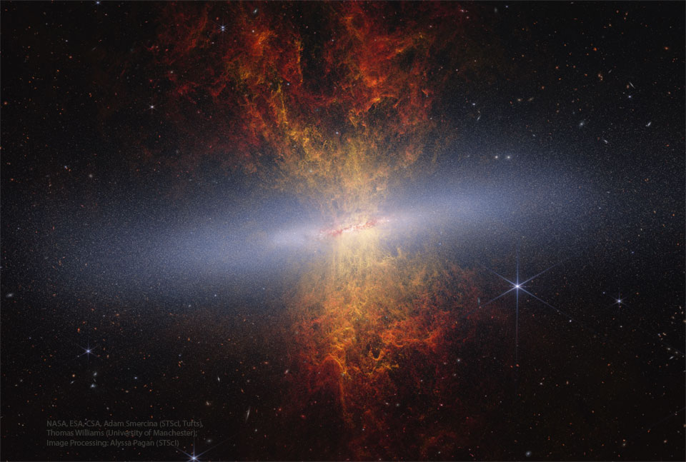 A starfield surrounds an unusual object with
a band of diffuse white crossing horizontally.
Emanating out from the band toward both the top
and the bottom of the frame is an orange and red
nebula.
Please see the explanation for more detailed information.