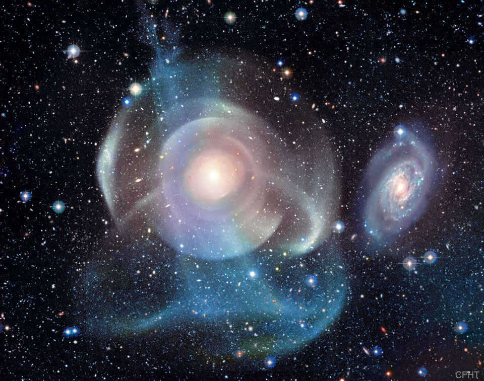 A starfield surrounds a complex background galaxy.
The galaxy center is surrounded by numerous shells, some
circular and concentric, but others colorful and
filamentary.
Please see the explanation for more detailed information.