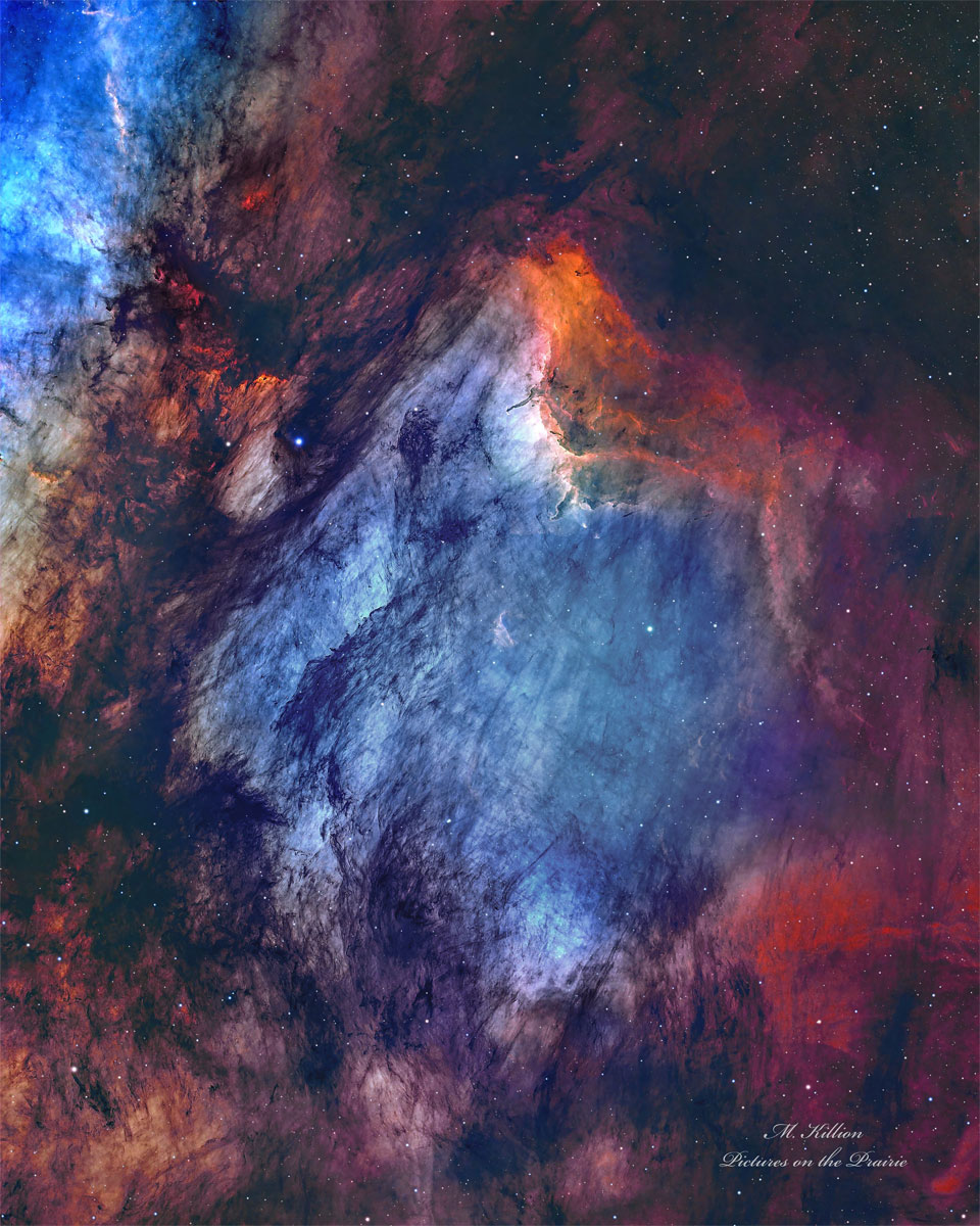 A busy starfield is dominated by red and blue glowing
gas and dark filamentary dust. The nebula appears to some
to have the shape of a pelican.
Please see the explanation for more detailed information.