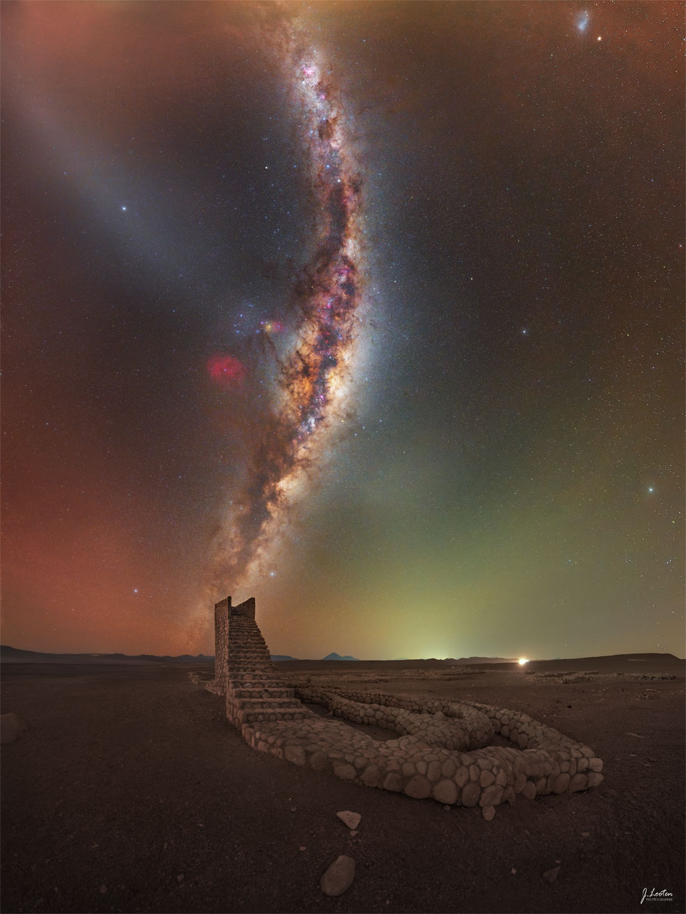 The Milky Way galaxy rises from the horizon and
curves upward in the sky. In the foreground, a rock pathway
is seen that culminates in a staircase that ends abruptly.
The Milky Way band appears to be a continuation of the
staircase.
Please see the explanation for more detailed information.